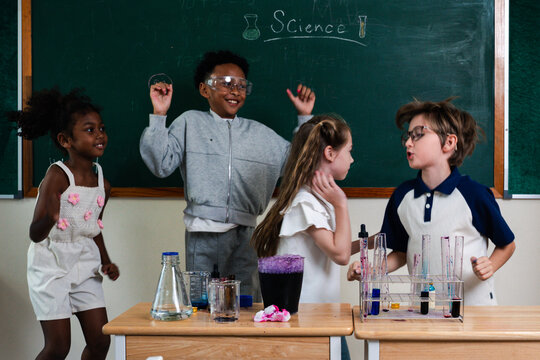 Education concept. Diverse elementary students conducting science experiment in classroom laboratory. test tubes, colorful liquid, promoting STEM education, teamwork, curiosity, learning. education