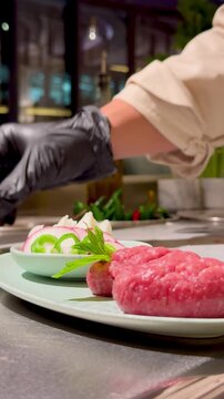Chef decorating raw Kibbeh with fresh mint leaves