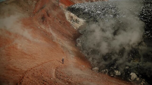 Tourists descend into a huge volcanic crater with solidified lava and fumarolic activity. View from crater rim