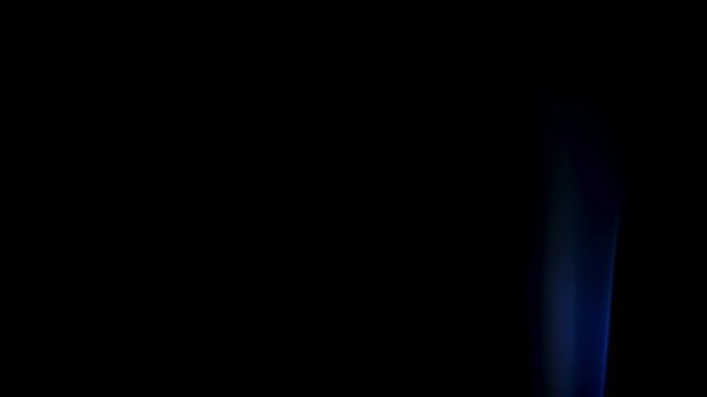 Macro footage of delicate smoke wisp floating in darkness, forming smooth and graceful shapes. scene conveys silence and stillness, representing concepts of meditation, balance and ephemeral beauty