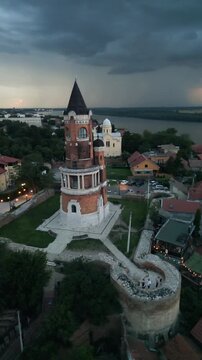 Vertical aerial orbit of Gardos Tower with lightning storm at dusk, Belgrade, Serbia.