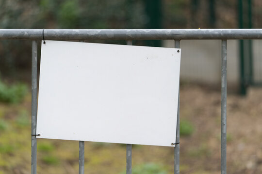  leeres weisses unbeschriftetes Schild mit Platz f&uuml;r eigenen Text an einem Zaun