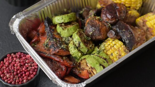 Vegetables such as corn, bell peppers, zucchini, and mushrooms grilled or barbecued, along with salt and spices for the dinner table. Grilled vegetables as a food background for your design