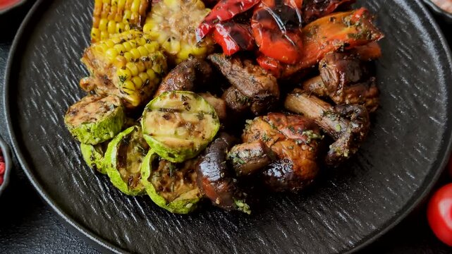 Vegetables such as corn, bell peppers, zucchini, and mushrooms grilled or barbecued, along with salt and spices for the dinner table. Grilled vegetables as a food background for your design