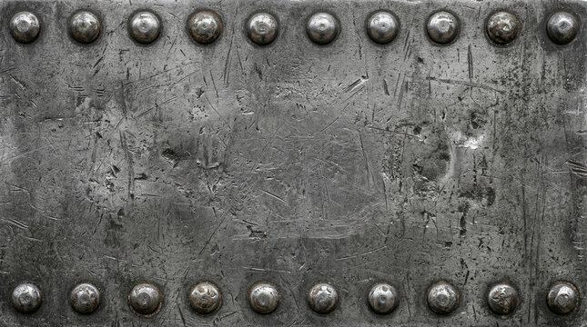 Grunge scratched dark metal plate texture with rivets and bolts on rough steel industrial background