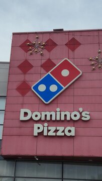Vilnius Lithuania 10.04.2026 Domino's Pizza restaurant exterior with famous fast food logo on modern building facade under cloudy sky urban commercial franchise concept