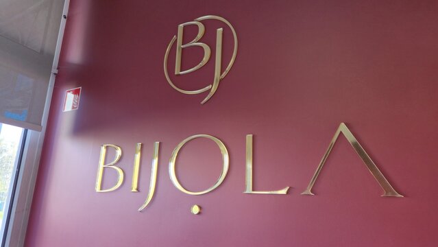Vilnius Lithuania 18.04.2026 Bijola pastry and cake boutique logo on stylish burgundy wall with golden letters elegant confectionery and dessert shop interior design