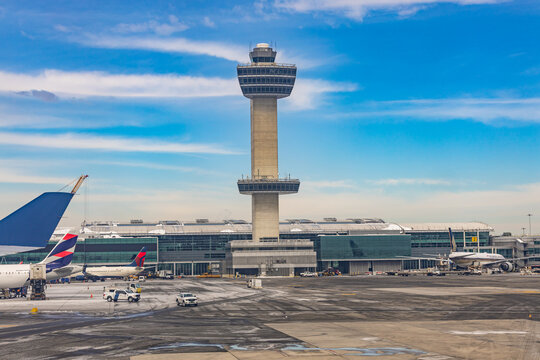 New York, USA - 22.01.2026: Air traffic control tower and commercial airplanes at the apron of John F Kennedy International Airport in New York City