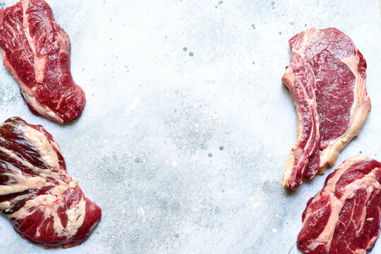 Raw organic marbled beef steaks with ingredients for making.