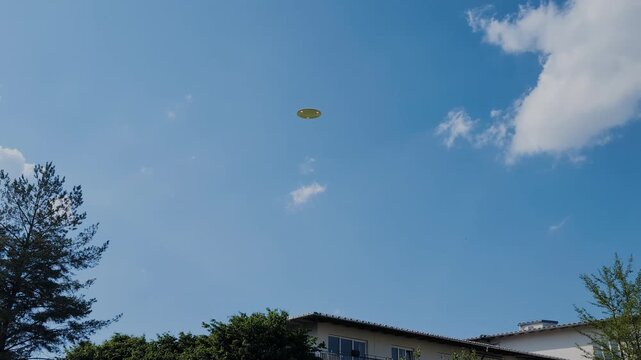 3D UFO over building in blue sky, spinning flying saucer with red lights, Corsica 1973 incident recreation, realistic extraterrestrial sighting