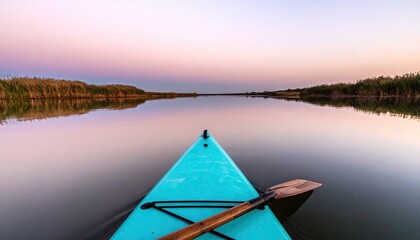 Obraz premium Kayak on calm water at sunset reflecting sky scenery horizon outdoors