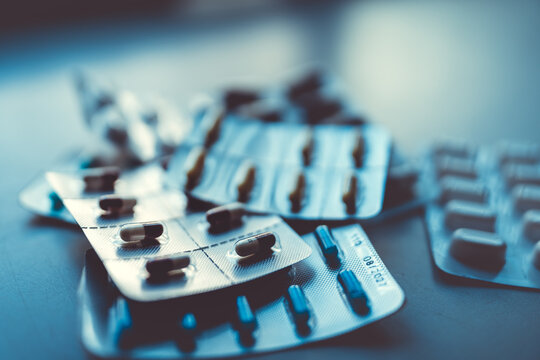 Assorted pharmaceutical blister packs with colorful pills and capsules