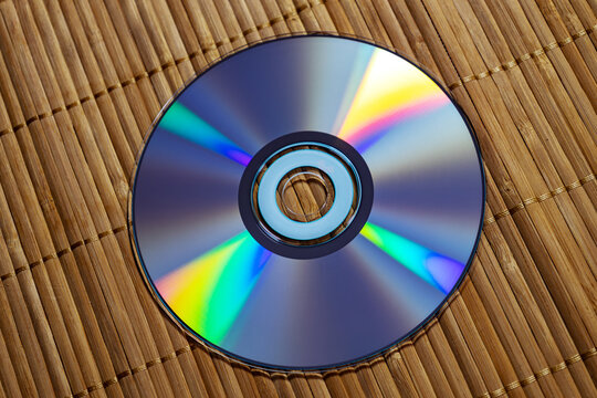 A DVD lies on a wooden surface. Top view