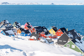 Dense greenlandic capital residential suburb with colorful Inuit houses, snow covered rooftops and arctic fjord shoreline, Nuuk, Sermersooq, Greenland © vadim.nefedov