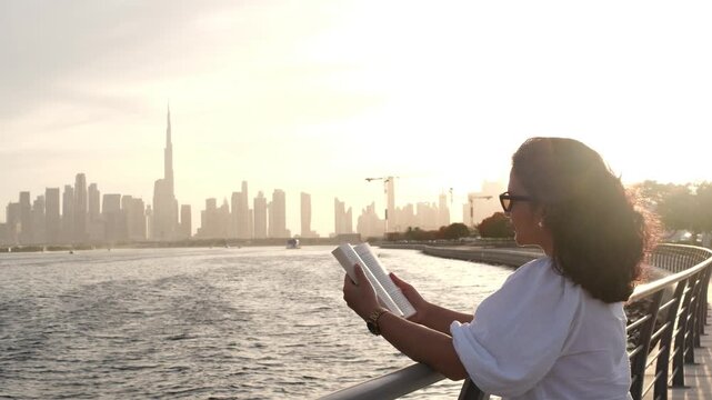 Female reader enjoying luxury urban lifestyle with Dubai skyline and waterfront video