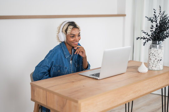 Young college student learning athome. girl with laptop sitting at the desk listening to the lecture,conference etc
