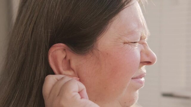 mature woman experiencing agony earache pain, touching ear, ringing and auditory hallucinations, hearing perception, mental health, unusual sounds, sensitivity Tinnitus symptom, sound perception