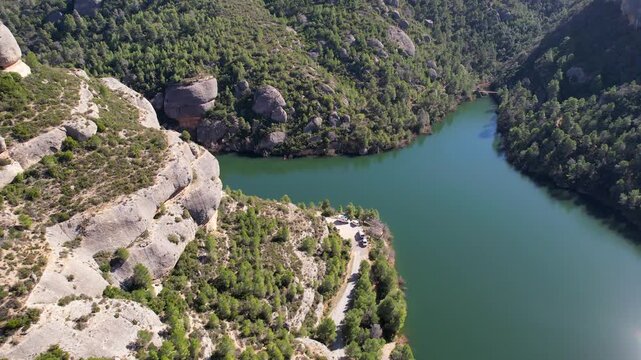 Forward reveal aerial shot of Margalef reservoir on sunny winter day. Tarragona Province, Spain.