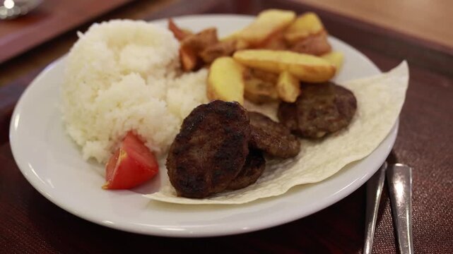 traditional Turkish meal with grilled meatballs, rice pilaf and fried potatoes