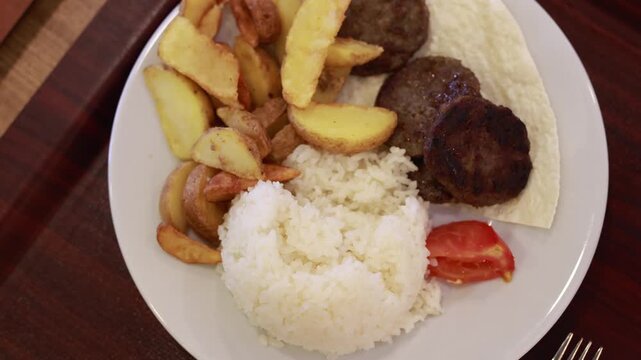 traditional Turkish meal with grilled meatballs, rice pilaf and fried potatoes