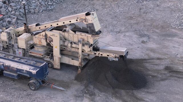 Espoo, Finland-April 14, 2025:Industrial machinery processing large gravel volumes at Finnish quarry, crushing stone for construction needs with heavy equipment operating in open landscape