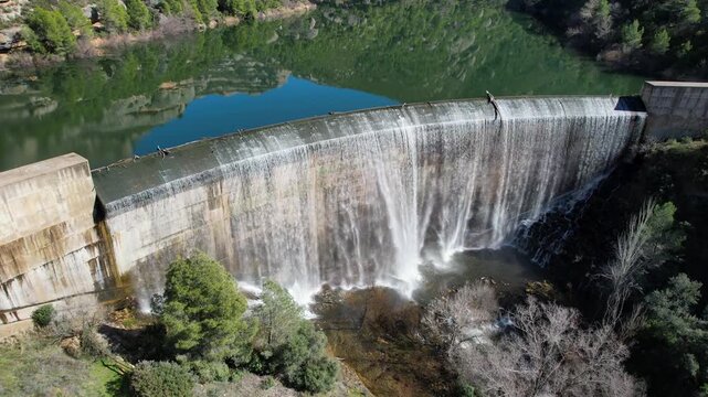 Tilt down aerial shot of Margalef dam with water flowing through. Tarragona Province, Spain.
