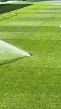 Watering the grass on a football stadium. Sprinklers Watering a soccer field in Portugal.