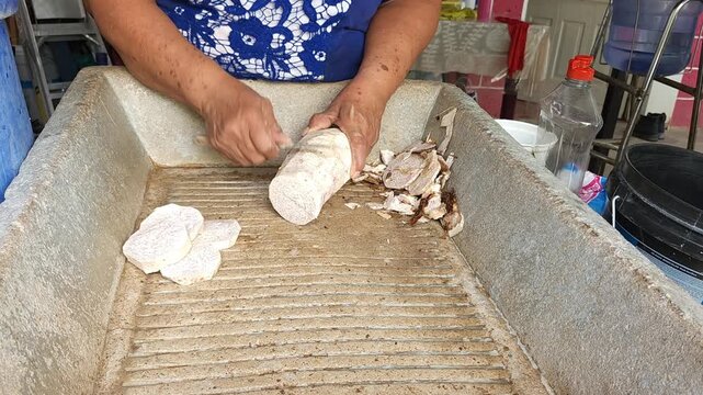Hand cleaning and preparing small pieces of sweet potato