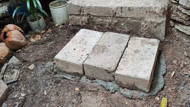Construction of a brick step using cement and three bricks