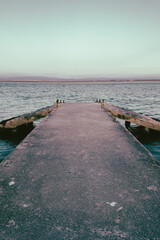 Fototapeta premium Concrete Pier Extending into the Calm Waters of Cais do Abrigo in Torreira Portugal