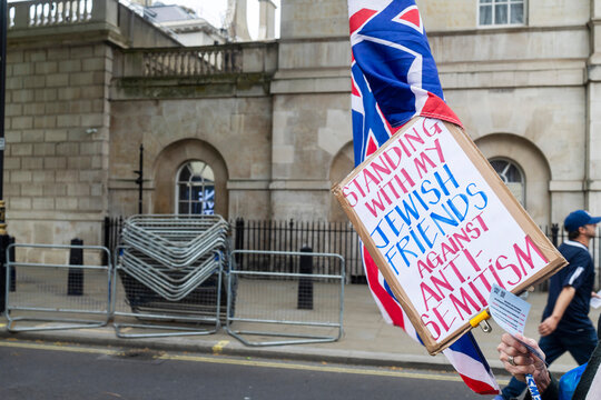 London, UK, Thousands of people gathered outside Downing Street for a protest against antisemitism. Cardboard protest sign saying Standing with my Jewish friends against anti-semitism 