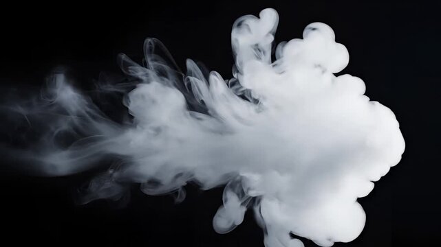 Abstract white smoke cloud expanding in darkness.