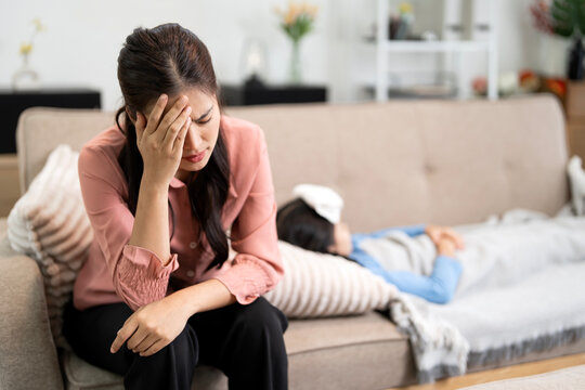 Stressed Asian Mother Worried About Her Sick Daughter at Home