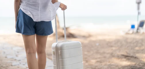 Travel lifestyle, Happy asian woman with luggage standing on tropical beach, Smiling young female tourist enjoying summer vacation at luxury resort, Tourism and weekend getaway destination concept © Art_Photo