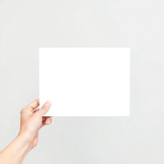 Fototapeta premium Hand holding blank white paper card against light gray background