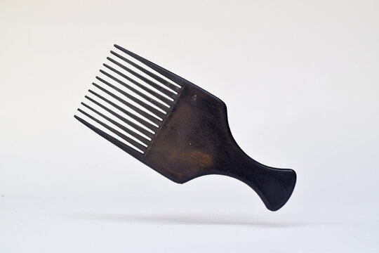 Elegant hair pick product featuring textured tines with levitation, white backdrop and diffused lighting in minimal style