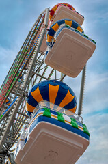 Colorful Ferris Wheel with Balloon Shaped Gondolas Against dramatic Cloudy Sky