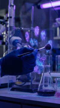 Forensic scientist analyzing fingerprints with ultraviolet light in a dark lab