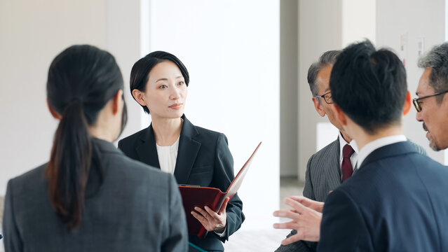 ミーティングする幅広い世代の男女ビジネスパーソンのグループ