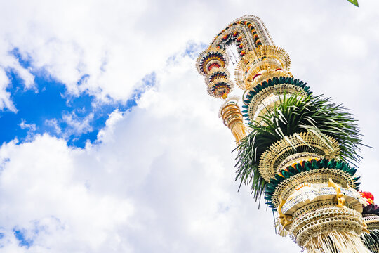 Traditional Balinese Penjor Decoration Against Blue Sky Background