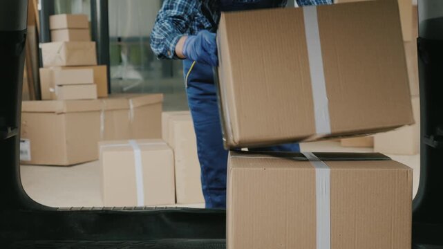 Professional courier loading cardboard boxes into vehicle trunk for express delivery.