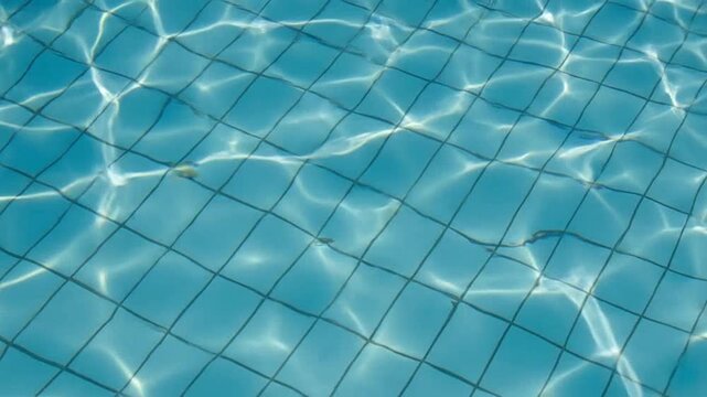 Clear water ripples over blue tiles in a swimming pool