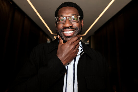 Smiling black man with glasses thinking about future