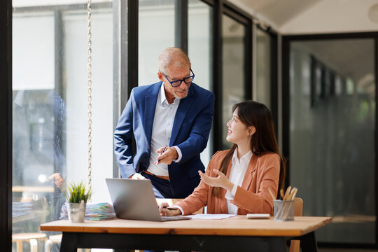 Business mentor guiding young professional during office meeting