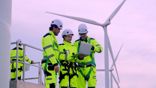 Wind turbine maintenance team collaborating on site renewable energy facility professional photography outdoor close-up teamwork
