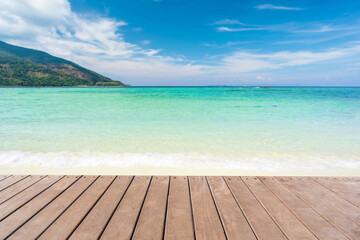 Fototapeta premium Peaceful summer landscape, wooden terrace overlooking the crystal clear sea and white sand beach and blue sky background