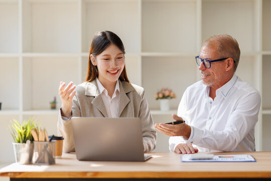 Business professionals discussing work on laptop in office