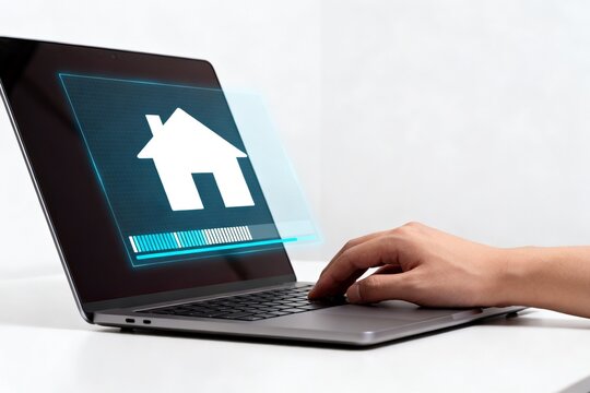 Hand using laptop with house icon