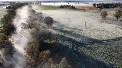 Obraz premium Aerial View of Morning Mist Rising From a River Through Rural Farmland