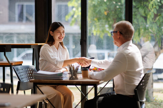 Professionals shaking hands confirming partnership and agreement in office